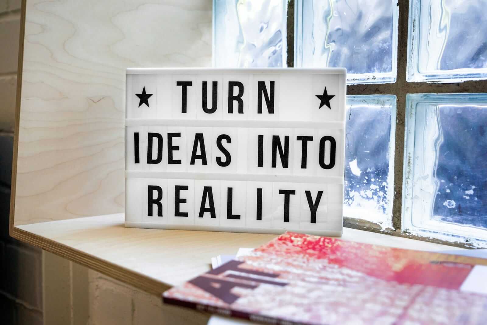 Inspirierendes Zitat auf Leuchtkasten: Ideen in Realität verwandeln.