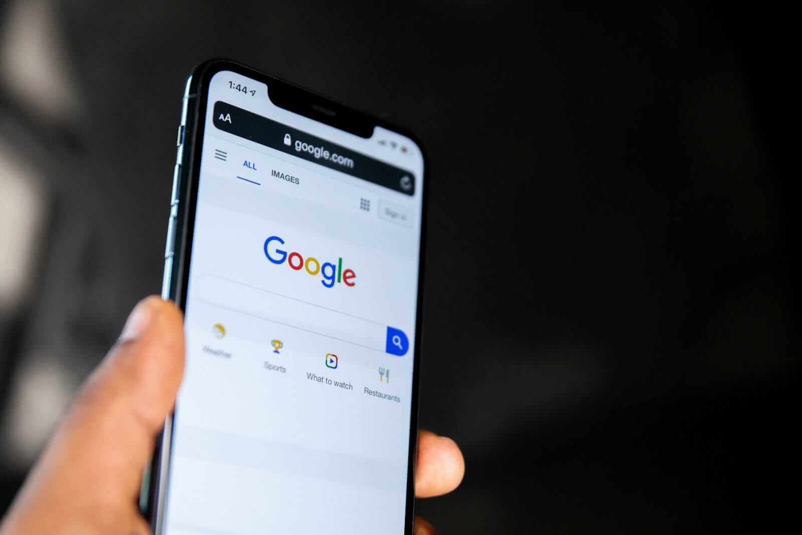 Hand hält Smartphone mit Google-Suchseite
