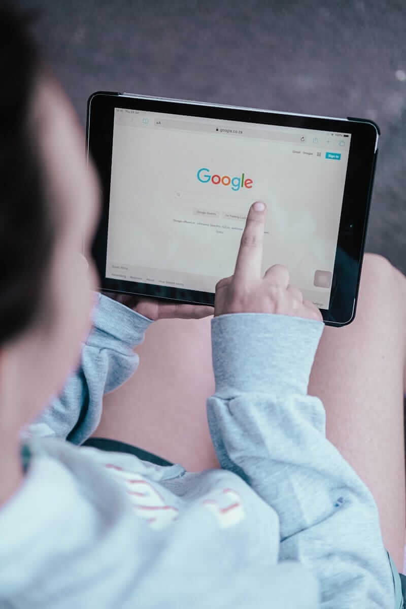 Person nutzt Google-Suche auf einem Tablet.